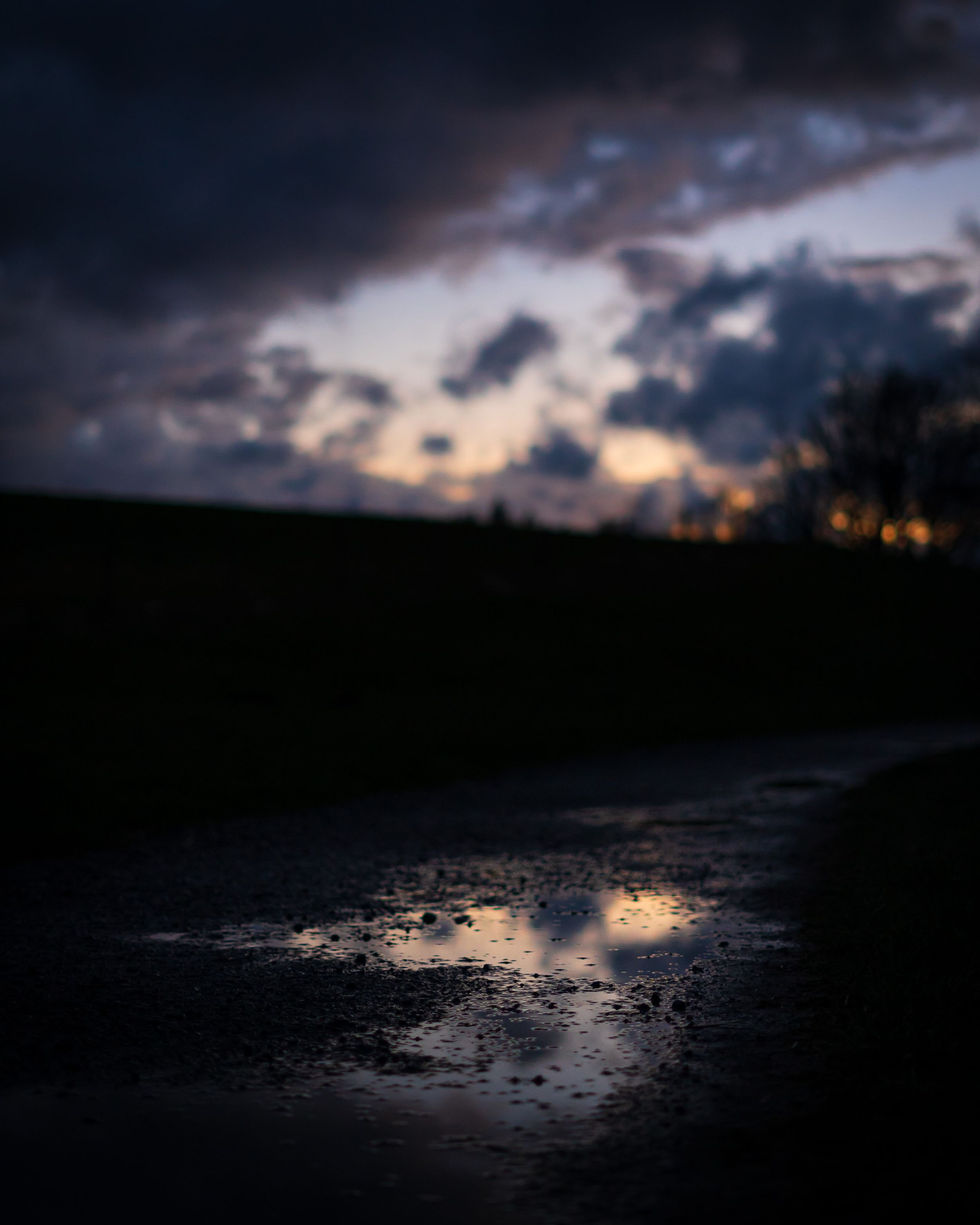 Pfütze in der sich der Abendhimmel spiegelt